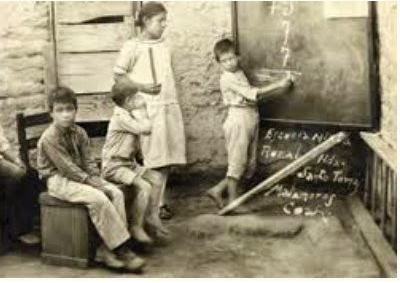 Maestra dando clases de matematicas a niños en una Escuela Rural.